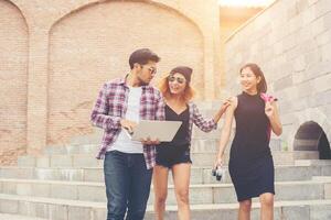 gruppo di studenti adolescenti felici hipster che camminano giù per le scale mentre parlano insieme. foto