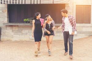 gruppo di adolescenti che vanno in giro in ambiente urbano, vacanze estive, divertimento allegro insieme. foto