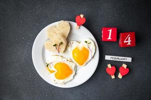 san valentino uovo fritto colazione sul tavolo uova strapazzate a forma di cuore foto