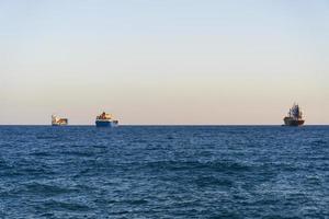 vista sul Mar Mediterraneo con tre navi all'orizzonte da un sentiero costiero di Limassol foto