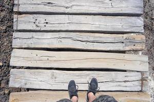 piedi in scarpe da ginnastica su una passerella di legno. foto