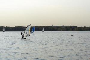 windsurfista. l'uomo sta navigando sullo sfondo dei grattacieli. uomo su una tavola da windsurf. windsurf in città. sport acquatici. navigare con una vela. attrezzatura da windsurf. stile di vita attivo. foto