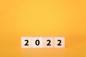 cubi di legno su fondo giallo e 2022. foto