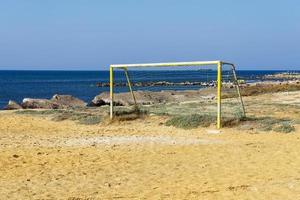 vecchia porta di calcio sulla sabbia vicino al mare. calcio in spiaggia vicino al mare. foto