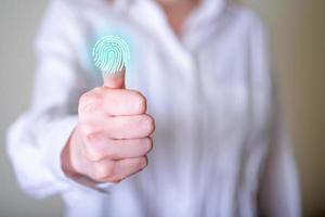 primo piano di una donna che esegue la scansione di un'impronta digitale sullo schermo. foto