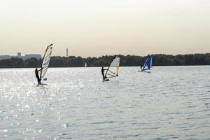 windsurfista. l'uomo sta navigando sullo sfondo dei grattacieli. uomo su una tavola da windsurf. windsurf in città. sport acquatici. navigare con una vela. attrezzatura da windsurf. stile di vita attivo. foto