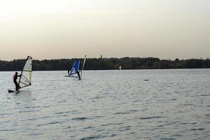 windsurfista. l'uomo sta navigando sullo sfondo dei grattacieli. uomo su una tavola da windsurf. windsurf in città. sport acquatici. navigare con una vela. attrezzatura da windsurf. stile di vita attivo. foto