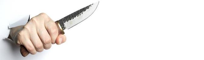 mano femminile che tiene un coltello su sfondo bianco. copia spazio. foto