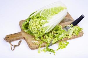 cavolo cinese verde fresco affettato sul tagliere di legno. foto in studio