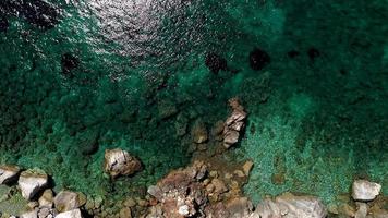 viste aeree dei droni su una costa rocciosa, acque cristalline del Mar Egeo, spiagge turistiche e tanto verde nell'isola di Skopelos, in Grecia. una vista tipica di molte isole greche simili. foto