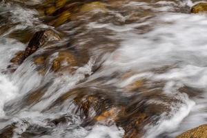 flusso di un fiume di montagna con pietre arrotondate foto