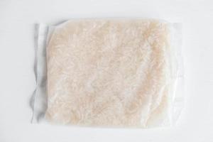 riso in un sacchetto di plastica su sfondo bianco foto