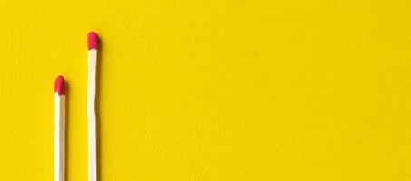 due fiammiferi isolati su uno sfondo giallo si chiudono con uno spazio vuoto per il testo foto
