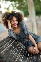 giovane donna nera con acconciatura afro sorridente in background urbano foto