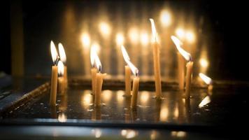 candele commemorative di cera che bruciano nella chiesa per i cristiani in lutto che hanno perso la loro famiglia foto