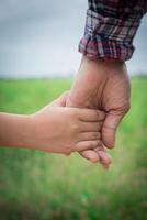 primo piano del padre che tiene la mano della figlia, così dolce, tempo in famiglia. foto