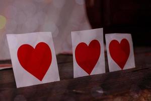 buon san valentino, cuori di carta su fondo di legno con sfondo di luci foto