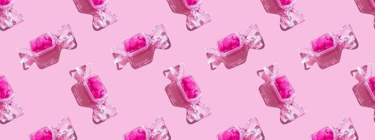 scatola trasparente a forma di caramella con lecca-lecca a cuore dolce con ombra dura su sfondo rosa spazio di copia. il concetto di san valentino, festa della mamma. striscione. modello foto