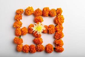 design rangoli di fiori di calendula con lampade a olio per il festival di diwali. foto