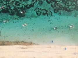 spiaggia di pandawa bali indonesia. barca turistica appoggiata sulla spiaggia foto