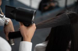 parrucchiere e bella donna del cliente che fanno il trattamento della cura dei capelli nel salone di stile di moda foto