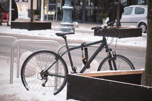 bicicletta parcheggiata in inverno vicino a scatola di albero di legno sulla neve foto
