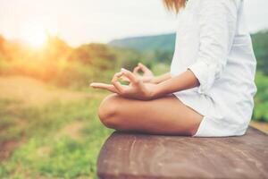 la donna passa meditazioni yoga e fa un simbolo zen con la mano. foto