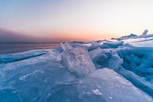 paesaggio marino invernale con ghiaccio rotto in primo piano al tramonto foto