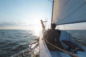 un uomo e una donna stanno viaggiando su uno yacht a vela. foto