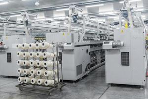 macchinari e attrezzature in officina per la produzione del filo. interno della fabbrica tessile industriale foto