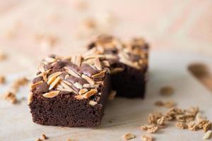 primo piano dolce brownie al cioccolato con guarnizione di mandorle, fuoco selettivo foto