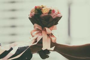 bouquet da sposa retrò con il fiore nelle mani della sposa foto