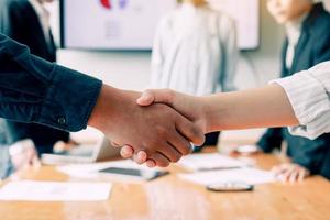 il team di imprenditori che collaborano si stringono la mano in un ufficio moderno. foto