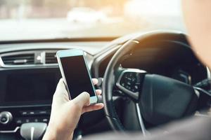 la mano dell'uomo sta usando il telefono durante la guida. foto