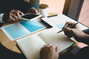 colleghi di partenariato commerciale che utilizzano un tablet per tracciare i rendiconti finanziari dell'azienda e i profitti, l'avanzamento del lavoro e la pianificazione nella stanza dell'ufficio. foto