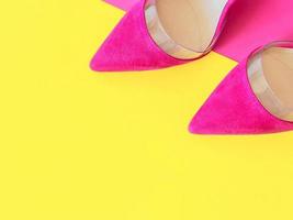 scarpe eleganti con tacco alto rosa su sfondo giallo e rosa. scarpe, moda, stile, shopping, concetto di vendita foto