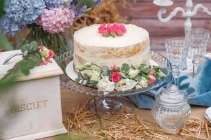 torta nuziale bianca decorata da fiori in piedi di tavola festiva. copia, spazio vuoto per il testo foto