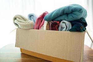 scatola per le donazioni con abiti usati a casa per sostenere l'aiuto ai poveri nel mondo. foto