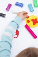 le mani dei bambini giocano la pasta per la creatività dei bambini. gioco da tavolo per lo sviluppo della motricità fine foto