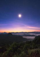 punto di vista montagna di nebbia colorata con la luna all'alba foto