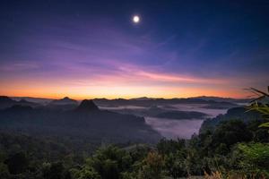 punto di vista luce solare sulla montagna con la luna all'alba foto
