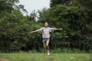 bambina carina felice che corre sull'erba nel parco foto