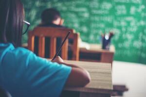 ragazza con disegno a pastello a lezione in classe foto