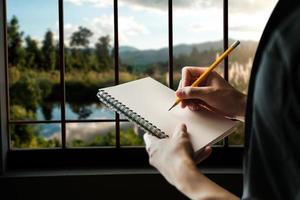 primo piano della mano della donna che scrive sta prendendo appunti stando in piedi foto