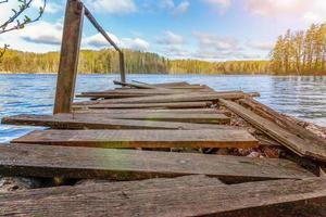 lago o fiume della foresta il giorno d'estate e vecchio molo o molo in legno rustico foto