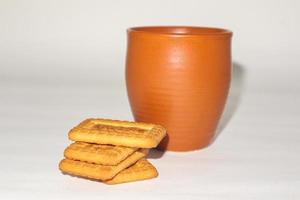 concetto di colazione mattutina. tazza di tè e biscotto su sfondo bianco. foto