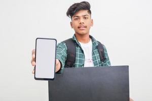 studente di college indiano che mostra la scheda e mostra lo schermo dello smartphone su sfondo bianco. foto