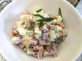 deliziosa insalata di olivier con verdure, salsiccia. foto