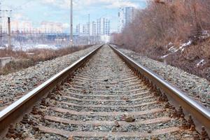 binari ferroviari paralleli si allontanano dal paesaggio urbano. foto