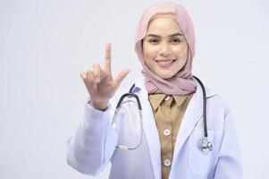 medico musulmano femminile con hijab su sfondo bianco studio. foto